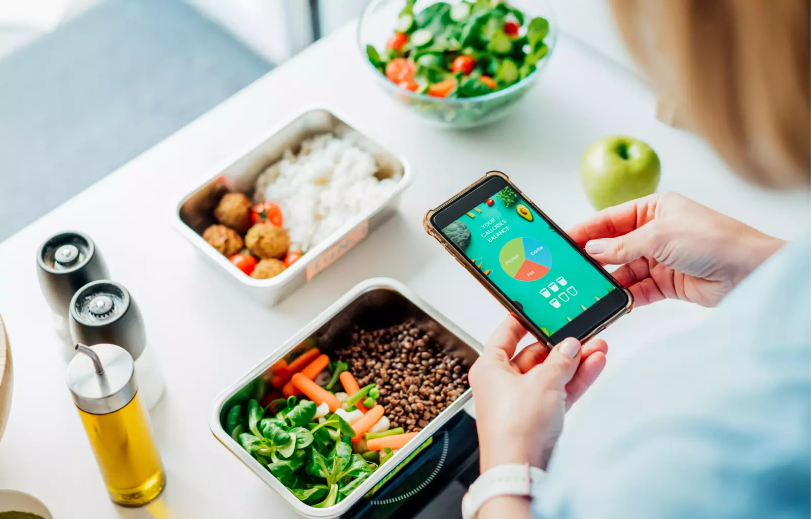 woman looking at health app and preparing a healthy meal