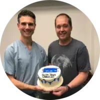 Dr. Pazona and patient holding a cake