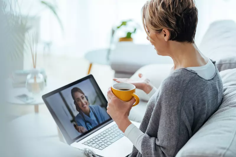 Woman sitting on her couch having a video call with her doctor.