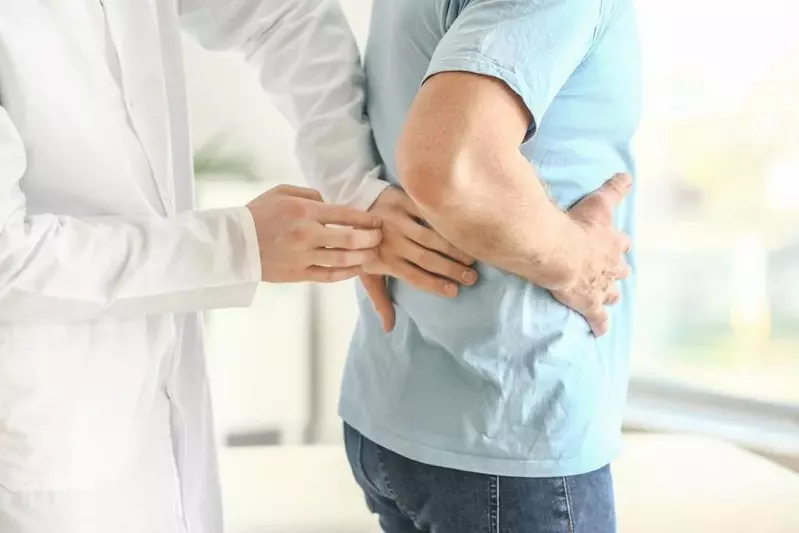 doctor feeling on the back of patient for kidney stones