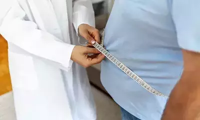 overweight man at doctor getting measured