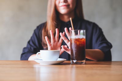 woman turning down two cups of coffee